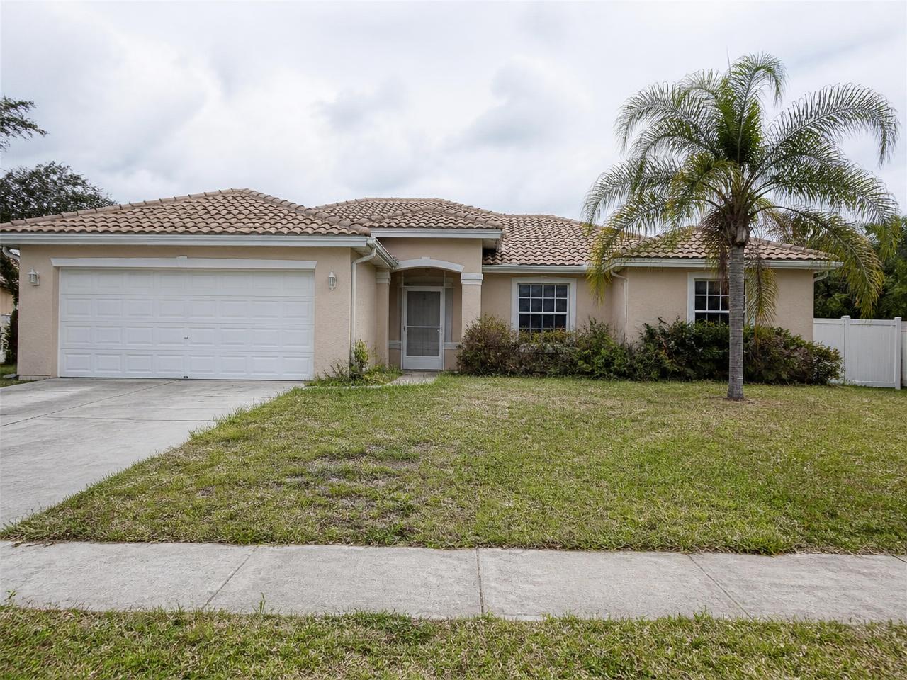 Overgrown hedges and thin mulch beds at a South Florida home before landscape renovation