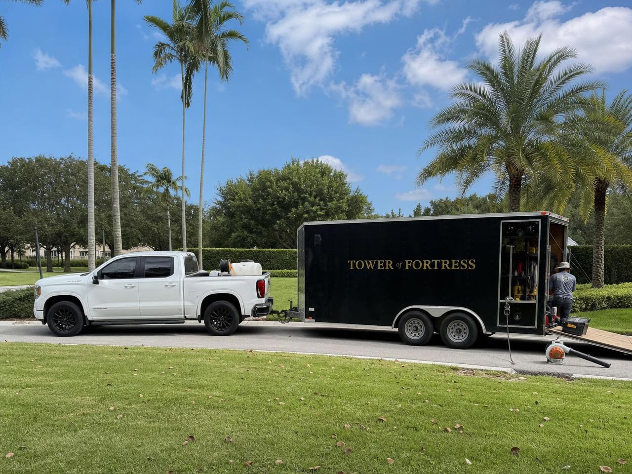 Landscaping truck and equipment trailer parked at a community job site